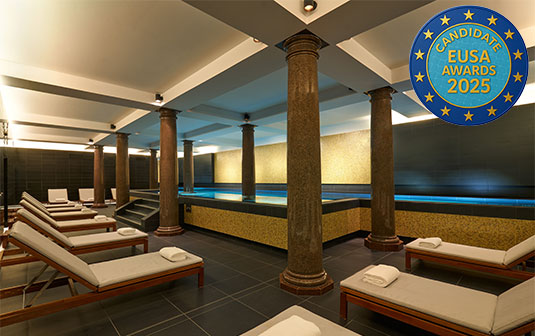 Ein elegantes Spa mit Liegen, Pool und Säulen. Ein Abzeichen "Candidate EUSA Awards 2025".